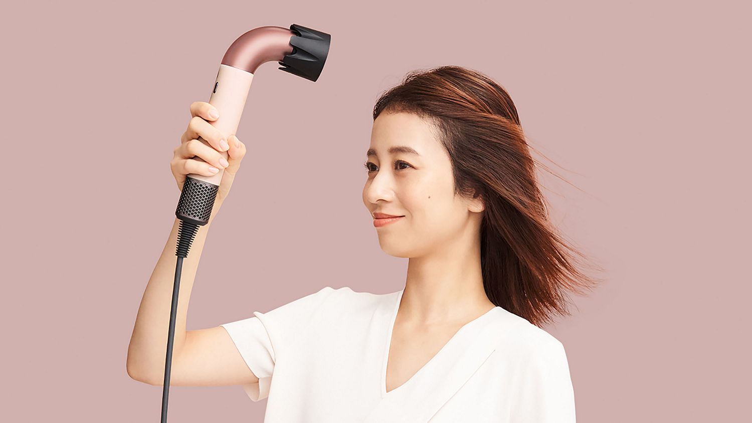 速乾ツールを取り付けて、髪の毛を乾かすモデル。